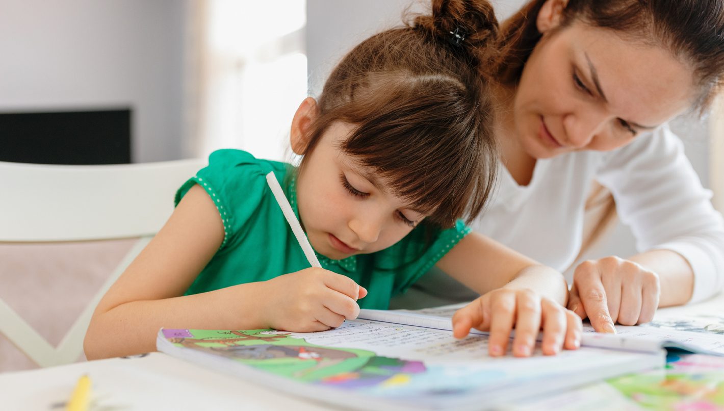 Mother helping daughter with homework.